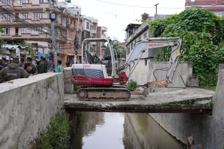 मनमती खोलामाथि बनेका अनधिकृत संरचनामाथि काठमाडौं महानगरको डोजर